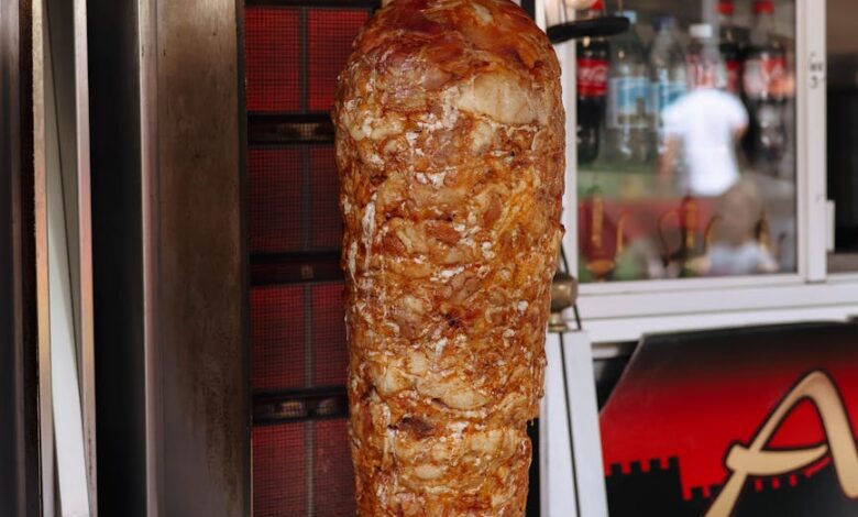 a large meat skewer is being cooked on a grill